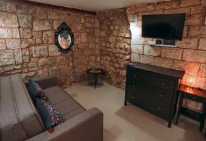 a living room with a couch and a flat screen tv at Tony Guesthouse in Acre