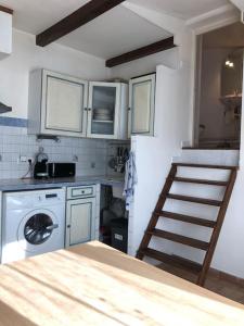 a kitchen with a staircase and a washing machine at Studio Proche L'Isle sur Sorgue in Le Thor