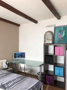 Studio Proche L'Isle sur Sorgue في ليه ثور: غرفة نوم بها مكتب وبه جهاز كمبيوتر