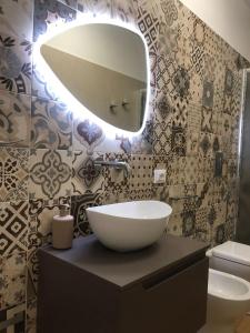 a bathroom with a sink and a large mirror at Mediterranea Apartment in Trapani