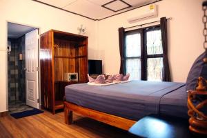 ein Schlafzimmer mit einem Bett mit rosa Kissen darauf in der Unterkunft Tropical Village Resort in Koh Samui  + 26 Fotos