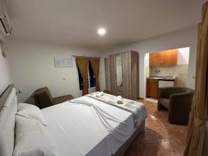 um quarto com uma grande cama branca e uma cozinha em Christopher's apartments em Ulcinj