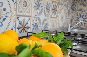 a pile of oranges sitting on top of a stove at Appartamenti La Baia del Raìs in Falcone