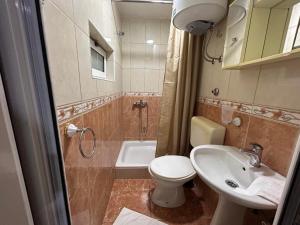 uma casa de banho com um WC, um lavatório e um chuveiro em Christopher's apartments em Ulcinj