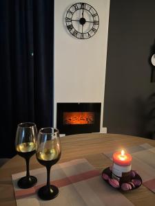 - une table avec deux verres de vin et une bougie dans l'établissement Apartman Ena Fojnica, à Fojnica