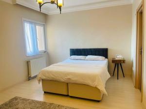 a bedroom with a bed with a blue headboard and a window at Beautiful Apartment for rent in Beylikduzu
