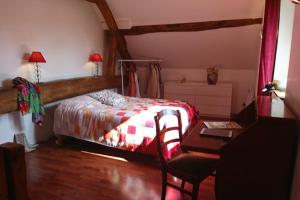 a bedroom with a bed and a desk and a table at maison en pierre atypique sur jardin paysagé 