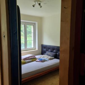 Dormitorio pequeño con cama y ventana en Appartement free WiFi en Breitenau am Hochlantsch