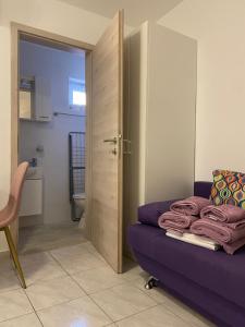 a bedroom with a purple couch and a bathroom at Studio Simoneta in Malinska +39 photos
