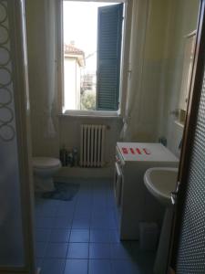 een badkamer met een wastafel, een toilet en een raam bij B&b A Casa Tua in Civitanova Marche