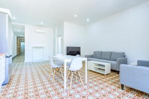 ein Wohnzimmer mit einem Tisch, Stühlen und einem Sofa in der Unterkunft Bieti Castellon in Castellón de la Plana