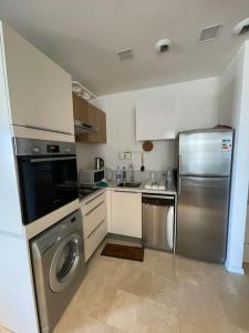 a kitchen with a stainless steel refrigerator and a dishwasher at Superbe Appartement sécurisé avec un balcon in Casablanca