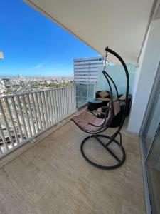 a chair on a balcony with a view of the city at Superbe Appartement sécurisé avec un balcon in Casablanca