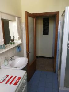 La salle de bains est pourvue d'un lavabo, d'un miroir et d'une porte. dans l'établissement B&b A Casa Tua, à Civitanova Marche