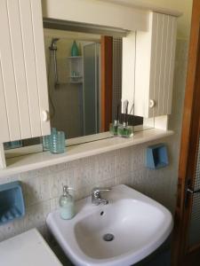 ein Badezimmer mit einem weißen Waschbecken und einem Spiegel in der Unterkunft B&b A Casa Tua in Civitanova Marche