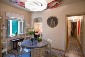 una sala da pranzo con tavolo e fiori di La Casetta di Borgo -Appartamento Peperone a Laiatico