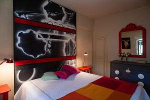 una camera da letto con un letto e un grande dipinto sul muro di La Casetta di Borgo -Appartamento Peperone a Laiatico