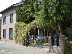 ヘールレンにあるHoliday home in a very quiet residential area of Heerlenの門と木のあるレンガ造りの家