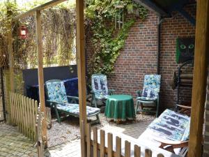 ヘールレンにあるHoliday home in a very quiet residential area of Heerlenのパティオ(椅子、テーブル、フェンス付)