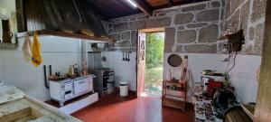 a kitchen with a stove and a stone wall at Moradia no Gerês - O Africanista in Soengas