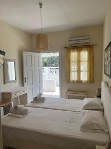 a bedroom with a large white bed and a desk at Peaceful House in Naxos Chora