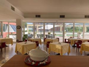 un restaurante con mesas y sillas y una olla en una mesa en Europalace Hotel Todi, en Todi