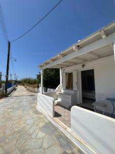 a patio with white furniture on a stone patio at Peaceful House in Naxos Chora