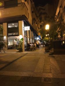 una calle vacía por la noche con mesas y sillas en Cozy Loft with Jazz Notes in Kolonaki en Atenas