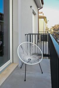 una sedia bianca seduta sul balcone di un edificio di LE MARIN contemporary apartments a Civitanova Marche
