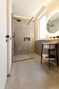 bagno con doccia, tavolo e specchio di LE MARIN contemporary apartments a Civitanova Marche