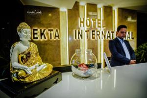 a man in a suit is standing next to a statue of a woman at Hotel Ekta International in Deoghar