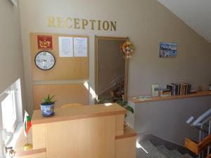 an office with a reception desk with a clock on the wall at Guest rooms Rusalka in Kranevo