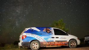 une camionnette blanche garée sous un ciel étoilé dans l'établissement Starlite View, à Valle