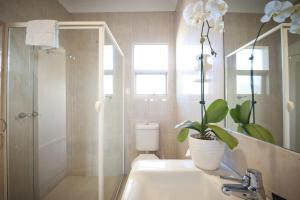 a bathroom with a shower, sink, and toilet at The Bluff Resort Apartments in Victor Harbor