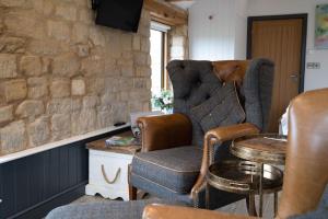 a living room with a chair and a table at The Cow Shed - Rural Barn Conversion in Little Bytham