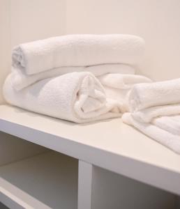 un mucchio di asciugamani seduti su uno scaffale di LE MARIN contemporary apartments a Civitanova Marche