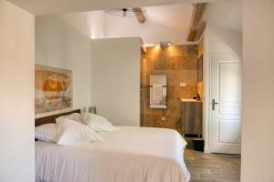 a bedroom with a white bed and a bathroom at Coeur de Provences in Saint-Didier