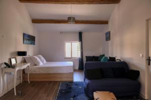 een woonkamer met een bed en een bank bij Coeur de Provences in Saint-Didier