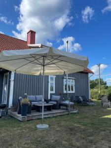 une terrasse avec un parasol, des chaises et une table dans l'établissement Semesterhus i Småland, à Söderåkra