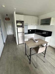 eine Küche mit einem Holztisch sowie einem Tisch und Stühlen in der Unterkunft Appartement au bord de mer in Saint-Brevin-les-Pins