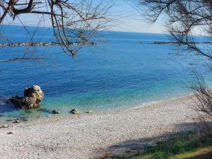 a beach with a large rock in the water at B&B BISCEGLIE in Bisceglie