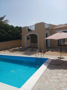 a house with a swimming pool and an umbrella at Casa Logos Stintino Country Paradise in Stintino