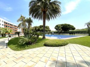 Un complejo con una palmera y una piscina. en LuxuryCambrils Resort&Spa, en Cambrils