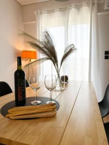 吉雄的住宿－Mimosa House，木桌旁的一瓶葡萄酒和两杯酒