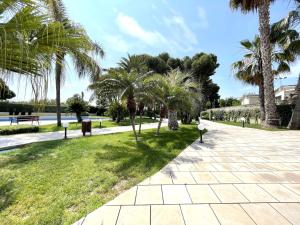 a park with palm trees and a walkway at LuxuryCambrils Resort&Spa in Cambrils