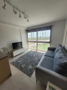 uma sala de estar com um sofá e uma grande janela em Apartamento duplex Mediterránean view em Gandia