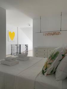 um quarto branco com uma cama com toalhas em Apartamento duplex Mediterránean view em Gandia