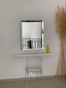 uma cadeira em frente a um espelho na parede em Apartamento duplex Mediterránean view em Gandia