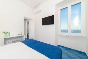 ein weißes Schlafzimmer mit einem großen Bett und einem Fenster in der Unterkunft La Dimora del Maestro in Amalfi