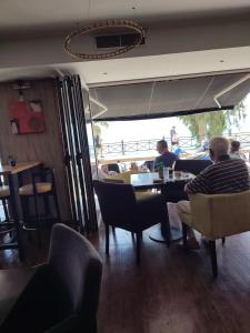 a man sitting at a table in a restaurant at By the oceam luxury studios in Piraeus